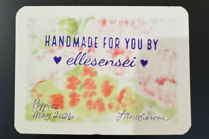 Handmade card with red floral design and text on a dark background
